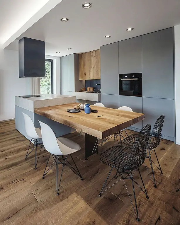 Одно и то же блюуст из жилого помещения используется в качестве backsplash в области раковины. Это не только добавляет к кухне промышленный элемент, но и объединяет открытое пространство, повторяя материал. Цвет стали также является хорошим контрастом для доминирующих серых тонов в кухонном шкафу, столешницах и стульях.
