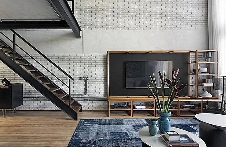 Удобное кресло Bauhaus дополняет расположение сидений, обрамляя набор журнальных столиков. Но основной предмет мебели в этой области - это не диван или стулья с акцентом. На самом деле это телевизионный блок, специально разработанный для этого пространства. Он держит телевизор на черной панели с открытыми полками внизу и слева от нее.