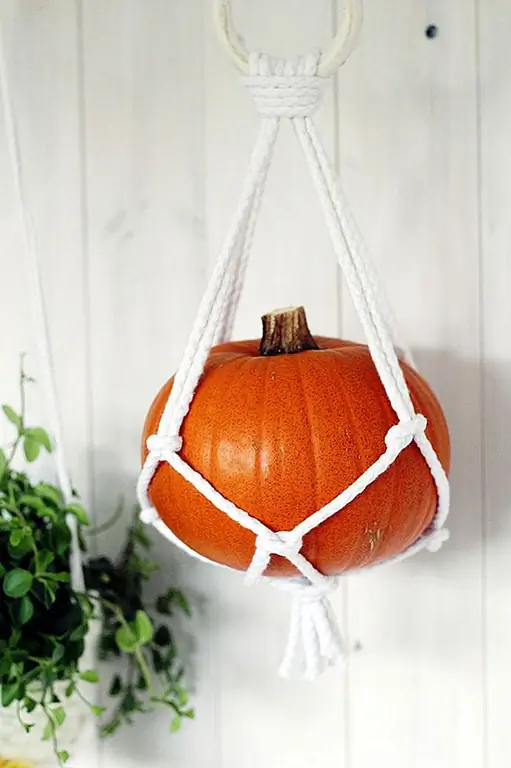 Вешалки для растений Macrame вернулись в стиле на некоторое время, поэтому я предполагаю, что у вас есть несколько в вашем доме. Для Хэллоуина замените комнатные растения тыквами для приятного и мгновенного изменения декора. (через Fall For DIY)