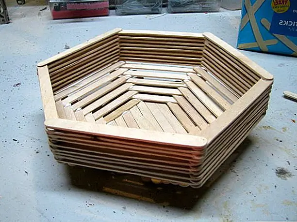 Еще одна корзина DIY из палочек Popsicle представлена на инструкциях. На этот раз дизайн немного сложнее, поэтому обязательно прочтите инструкции. Вам понадобится куча палочек для ремесел и некоторый клей. Начните с формы шестиугольника и продолжайте оттуда.