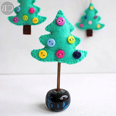 Дерево украшения, изображенные на Buddlycrafts действительно мило тоже. Они сделаны из зеленого и коричневого войлока, и они украшены цветными кнопками, которые выглядят как украшения. Вы можете либо повесить их на свою настоящую рождественскую елку, либо вставить палочку или шампунь в основание деревьев, а затем в большую деревянную бусину или швейную бобину.