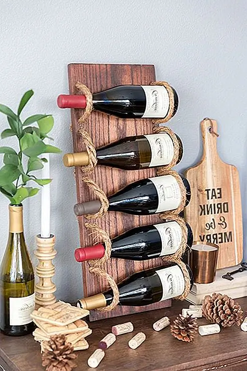 Еще один простой в изготовлении винный шкаф дизайн можно найти на cambriawines. На этот раз дизайн немного деревенский. Чтобы сделать подобную винтовую стойку, вам понадобится деревянная доска, несколько веревок из манилы, силовая дрель с ½-дюймовой лопатой, наждачная бумага, пятно на дереве и кисть или губка, горячий пистолет для клея и гвозди для ног. После того, как вы разрезаете доску, слейте края, а затем просверлите 10 отверстий на каждой стороне доски. Слейте отверстия. Затем окрасьте доску и добавьте веревку. Вставьте его через отверстия, приклейте края, чтобы предотвратить изнашивание, а затем закрепите концы доски гвоздями.
