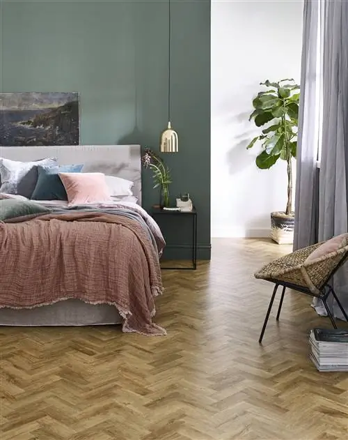 Спальня с дубовым паркетом LVT, кроватью, стулом и зелеными стенами. Спальня с дубовым паркетом LVT, кроватью, стулом и зелеными стенами.