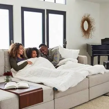 семья на диване в одеяле Lovesac семья на диване в одеяле Lovesac