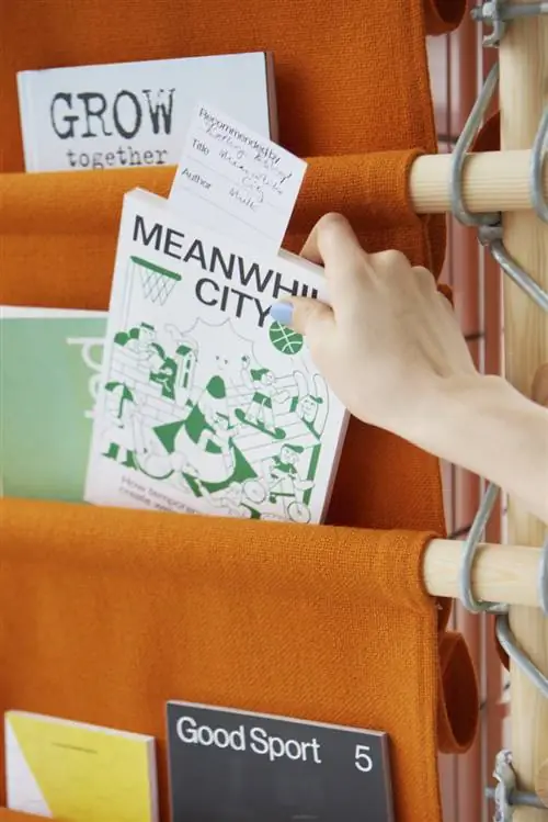 рука вытаскивает книгу из стеллажа рука вытаскивает книгу из стеллажа