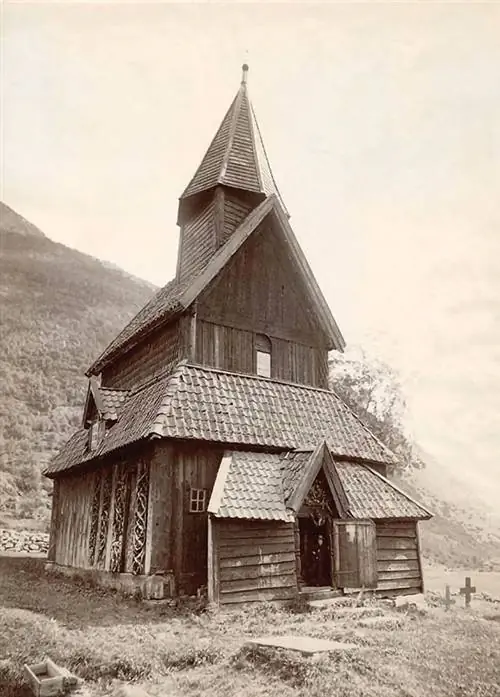 Церковь Урнеса примерно в 1890 году, демонстрирующая «необычайную» повторно использованную резьбу на северной внешней стене (внизу слева) Аксель Линдал Церковь Урнеса примерно в 1890 году, демонстрирующая «необычайную» повторно использованную резьбу на северной внешней стене (внизу слева) Аксель Линдал
