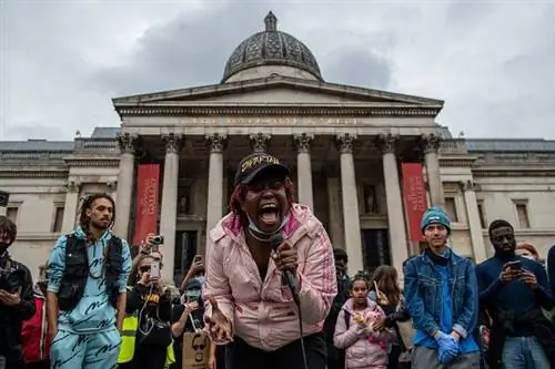 Сторонник Black Lives Matter поет перед толпой, которая прошла с ней маршем перед Национальной галереей на Трафальгарской площади 12 июня в Лондоне. Сторонник Black Lives Matter поет перед толпой, которая прошла с ней маршем перед Национальной галереей на Трафальгарской площади 12 июня в Лондоне.