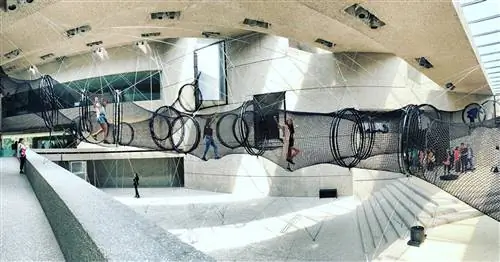 Посетители пробираются через Decision Tubes Карстена Хёллера (2019), сетчатые туннели, подвешенные в атриуме Museo Tamayo.